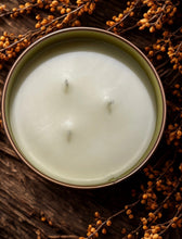 Carica l'immagine nel visualizzatore di Gallery, Overhead view of triple-wick bourbon butterscotch candle surrounded by fall decor
