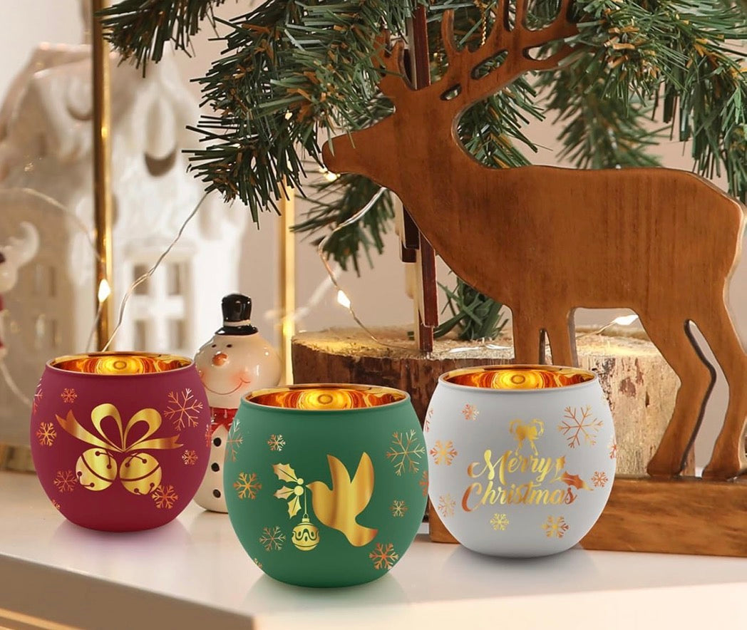 Christmas tealight candle holders displayed under a holiday tree with snowman and reindeer decor.