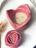 Pink rosebud coconut wax candle in a pink rose shape container, labeled "mermaid Glow Edition", styled with pink petals
