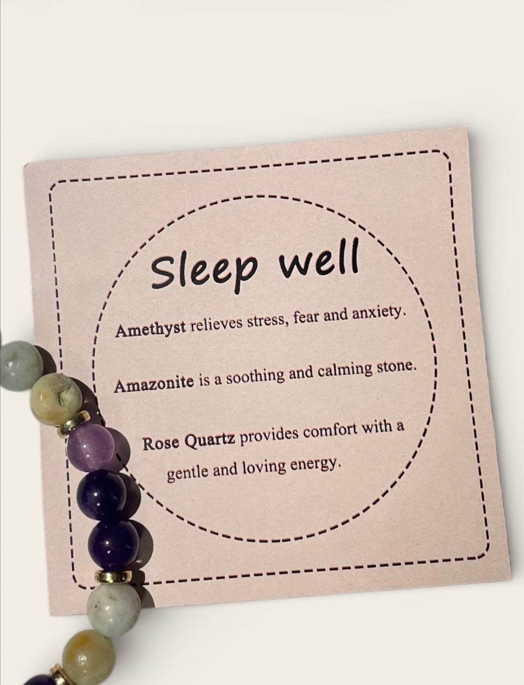 Card with 'Sleep well' text and amethyst, amazonite, and rose quartz beads on a white background