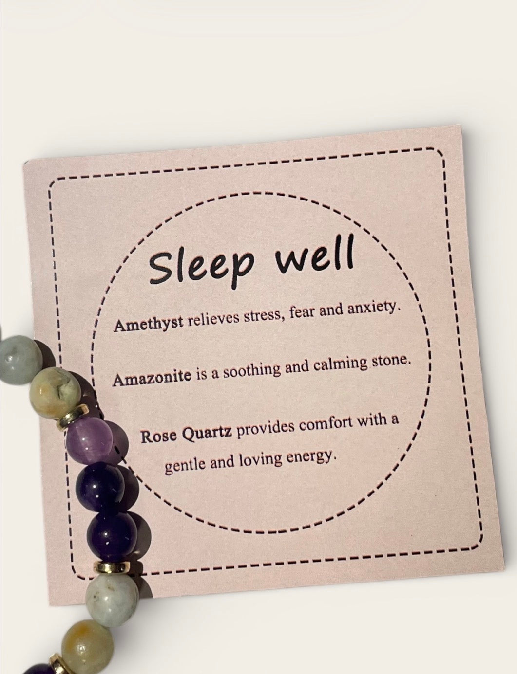 Card with 'Sleep well' text and amethyst, amazonite, and rose quartz beads on a white background