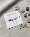 Anxiety relief crystal bracelet with rose quartz and agate displayed on branded card in minimalist neutral setting