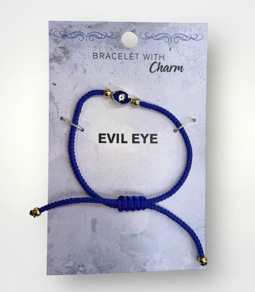 Blue bracelet with an evil eye charm on a gray card