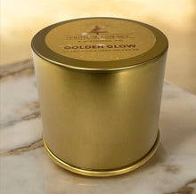 Cargar imagen en el visor de la galería, Gold twist-top candle tin labeled Golden Glow. Premium handmade coconut-wax candle in Christmas Splendor scent, elegant holiday gift idea.
