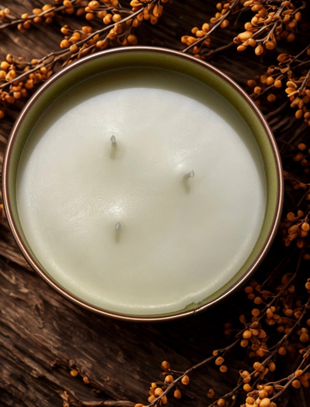 Overhead view of triple-wick bourbon butterscotch candle surrounded by fall decor