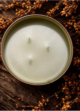 Load image into Gallery viewer, Hand-poured Butterscotch Velvet candle in a copper tin with three cotton wicks, styled with autumn berries on rustic wood.
